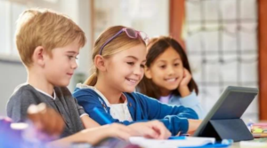 image shows school kids looking at computer thinking about fundraising online