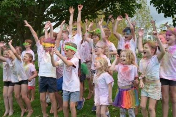 image shows students having fun and jumping around at a school colour run fundraiser event